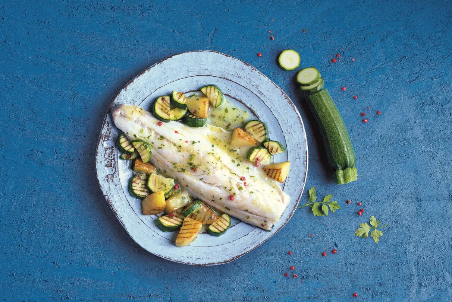 Bass fillet with pink pepper, potatoes and grilled courgettes